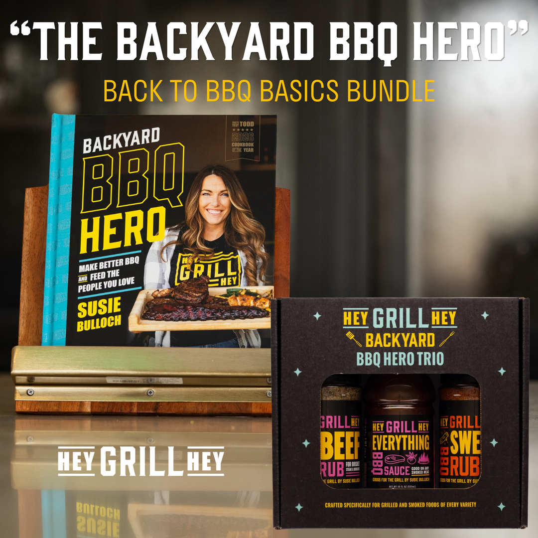 Backyard BBQ Hero Back to BBQ Basics Bundle featuring the book 'Backyard BBQ Hero' by Susie Balloch and the Hey Grill Hey BBQ Hero Trio seasoning bottles in a black gift box.