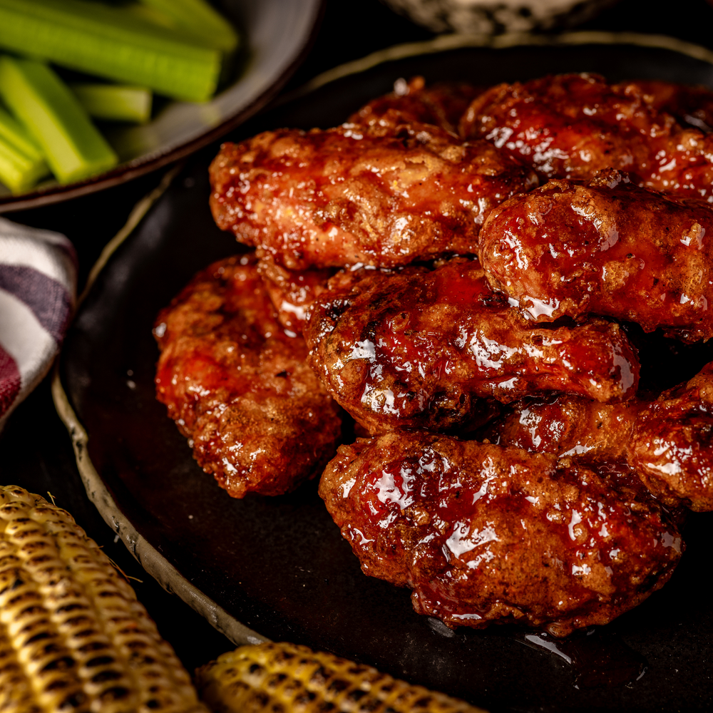 A close up shot of a plate full of smoked and fried chicken wings.